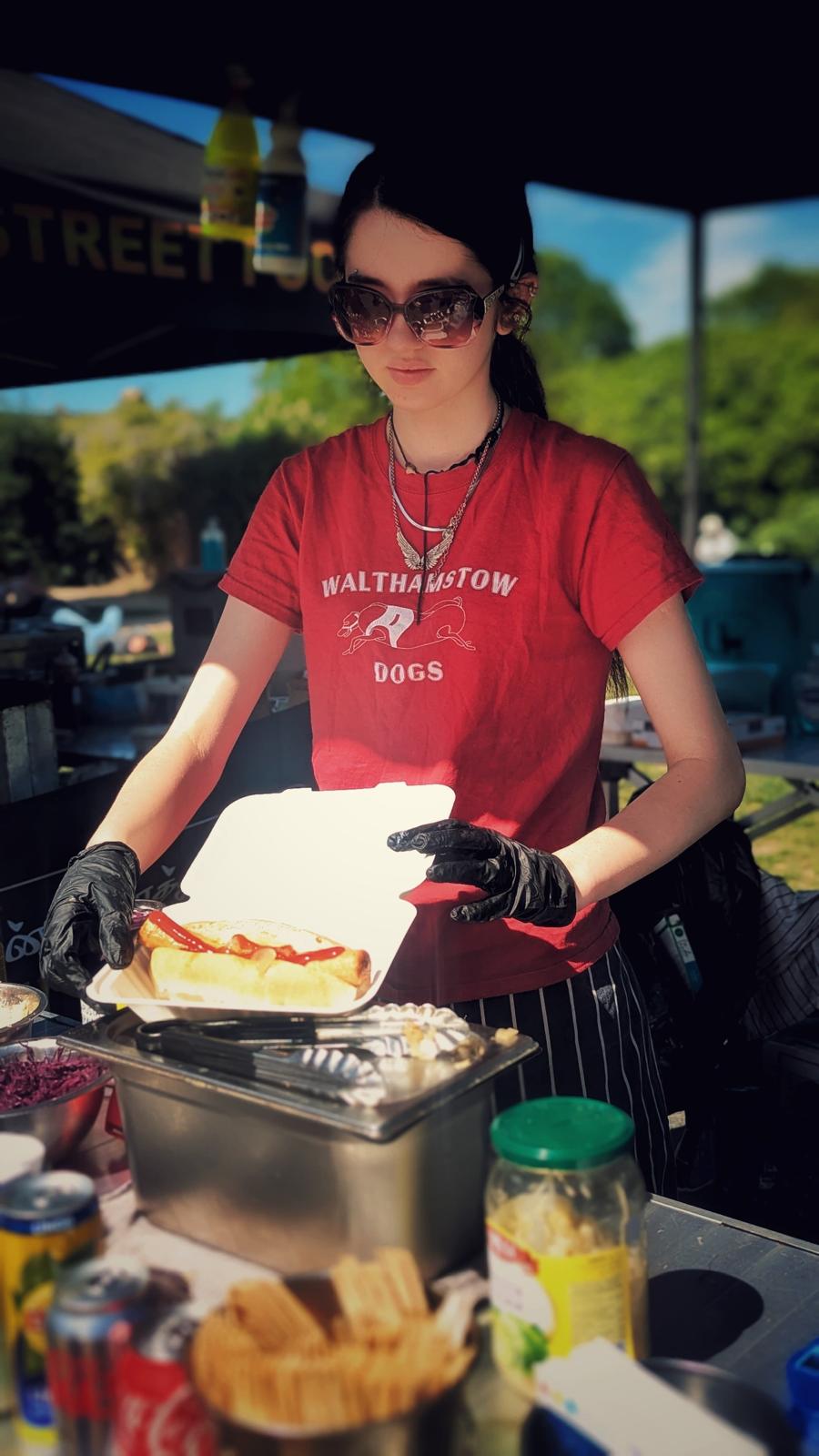 Team member serving a hot dog