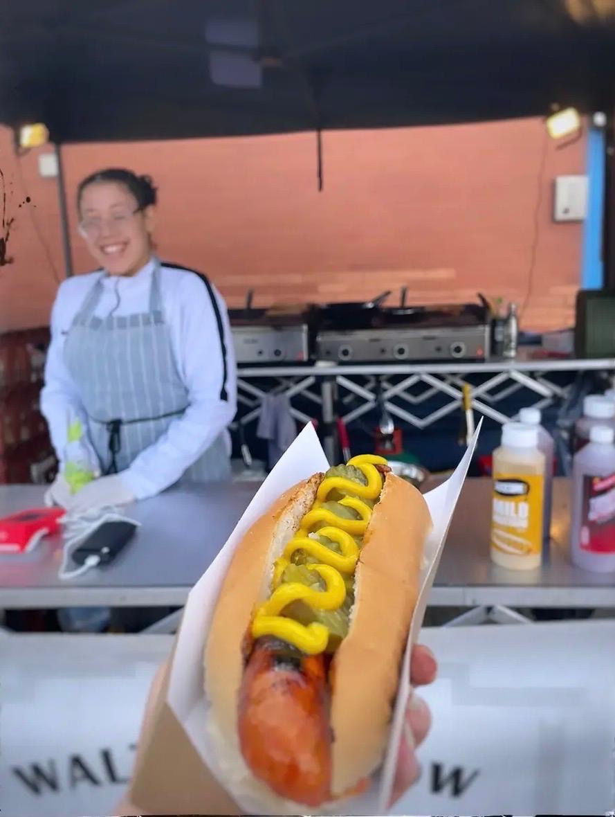 Hot dog with mustard held up at the Walthamstow Dogs stand